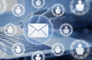 Futuristic blue and white circled envelopes and people icons with person typing on a laptop