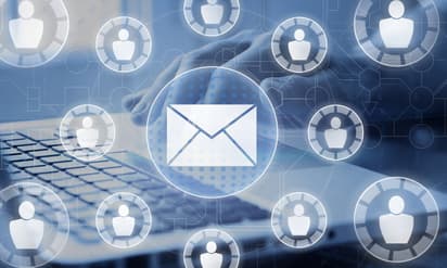 Futuristic blue and white circled envelopes and people icons with person typing on a laptop